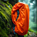 Bright orange waterproof rain cover on hiking backpack in light rain
