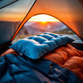 Self-inflating ultralight camping pillow on sleeping bag inside tent at dawn