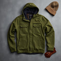 Olive green polar fleece tactical jacket with hood flat lay with beanie and gloves