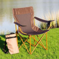 Golden aluminum alloy folding camping chair with carry bag on grass by lake