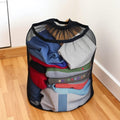Large mesh drawstring laundry travel bag on hardwood floor