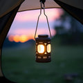 Solar USB camping lantern hanging in tent doorway at dusk with warm glow