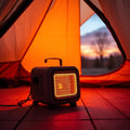 Portable 1500W tent heater glowing warm inside a canvas tent at dusk