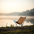 Ultra-light folding camp chair beside a misty lake at dawn